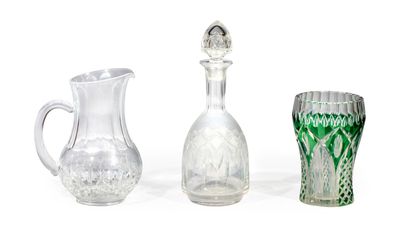 trois vases en verre et un pichet en verre posés sur une surface blanche