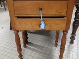 a small wooden table with a drawer on top of it