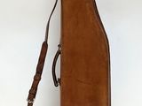 étui à guitare en cuir marron sur fond blanc, muni d'une sangle