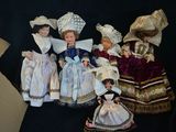 a lot of dolls that are sitting on a black surface