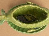 a green bowl with a fish inside of it on a table