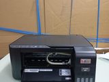 a printer sitting on top of a table in front of a cardboard box