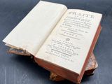 an open book sitting on top of a piece of wood on a table