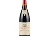 a bottle of red wine sitting on top of a white table