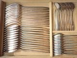 many spoons and forks in a box on the table