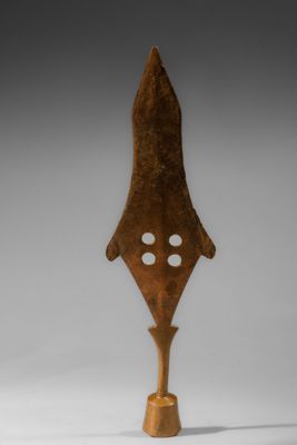 une sculpture en bois représentant une flèche percée de trous
