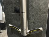 a stainless steel hand dryer on the wall in a public bathroom