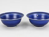 a pair of blue bowls sitting on top of a white table