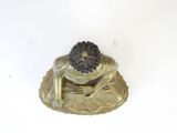 a small statue of a frog sitting on a leaf