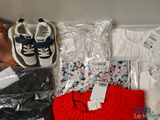 a pile of clothing and shoes on a table