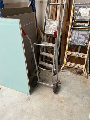 a ladder that is next to a pile of wood