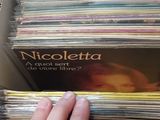 a person holding a stack of cds in a box