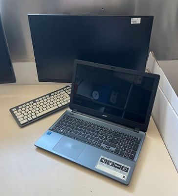 a laptop computer sitting on a desk next to a monitor and keyboard