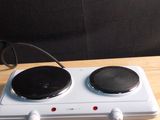 a white stove top with two burners on a wooden table