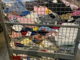 a metal cart filled with lots of clothes in a warehouse
