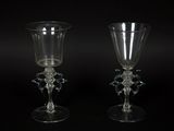 two clear glass goblets sitting next to each other on a black surface