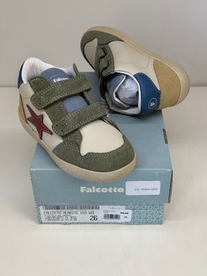 des chaussures de petit garçon dans une boîte posée sur une surface blanche