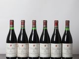 six bouteilles de vin rouge alignées sur une table en bois