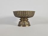 un bol ancien en laiton orné d'un motif décoratif sur le socle