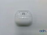Des AirPods d'Apple sont posés sur une surface blanche