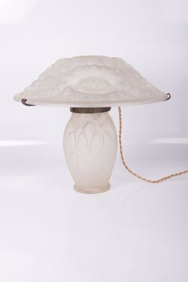 une lampe de table blanche surmontée d'un abat-jour en verre
