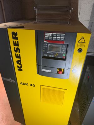 une machine jaune posée sur le sol, près d'un mur