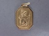 une médaille d'or sur laquelle figure le portrait d'un homme
