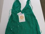 a green bag on a white table with a tag on it