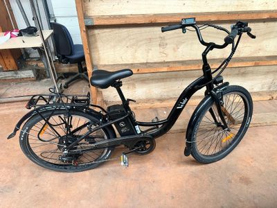 a black bike parked in front of a wooden wall