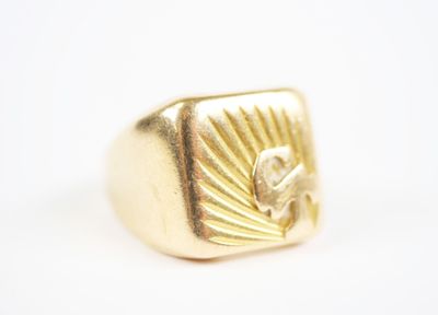 an image of a gold signet ring with a flower in the center