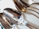 four spoons and two spoons on a plate with oranges