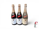 three bottles of champagne sitting next to each other on a white surface