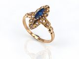 a close up of a gold ring with a blue stone