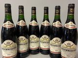 six bouteilles de vin sont alignées sur une table