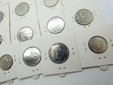 Plusieurs pièces d'argent de 25 centimes sont alignées sur une surface blanche