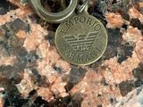 a keychain that has a coin on it on a rock
