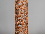 carved wooden sculpture of birds and flowers on a tall stand