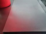 a red cup sitting on a table next to a laptop