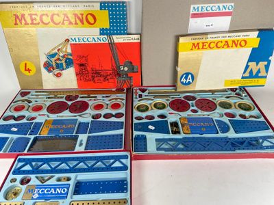 three boxes of meccano are sitting on a white surface