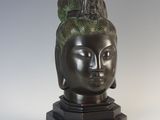 sculpture of a woman ' s head on a black base with a green headband