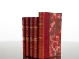 three red books sitting on top of a table next to each other