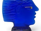 a blue glass sculpture of a woman ' s head on a stand
