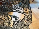 a metal sculpture of a hand holding a wine glass on a table