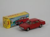 a red toy car next to a yellow box on a white surface