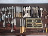 a lot of silverware on a table with a pair of scissors