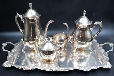 a silver tray with a silver tea set on it