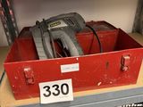 a red box with a tool on top of it on a shelf