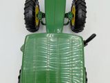 a green toy tractor with four wheels on a white surface