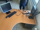 a man that is standing in front of a desk with a computer on it