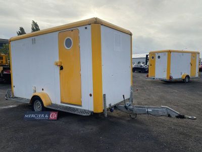 remorque jaune et blanche dans un parking, avec d'autres remorques en arrière-plan